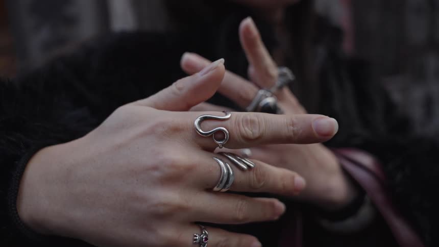 Close up slow motion of a woman's hands with many stylish silver rings