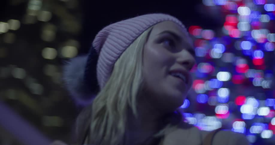 A woman is smiling as she takes photographs