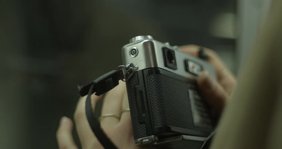 A woman is holding a camera in a moving train