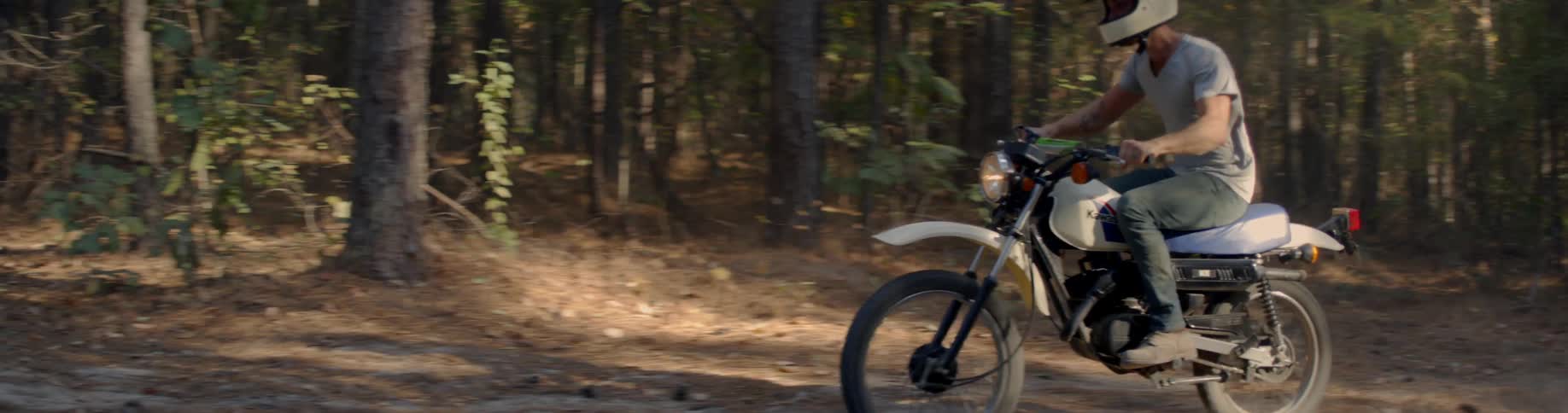 A man drives a bike across a dirt path