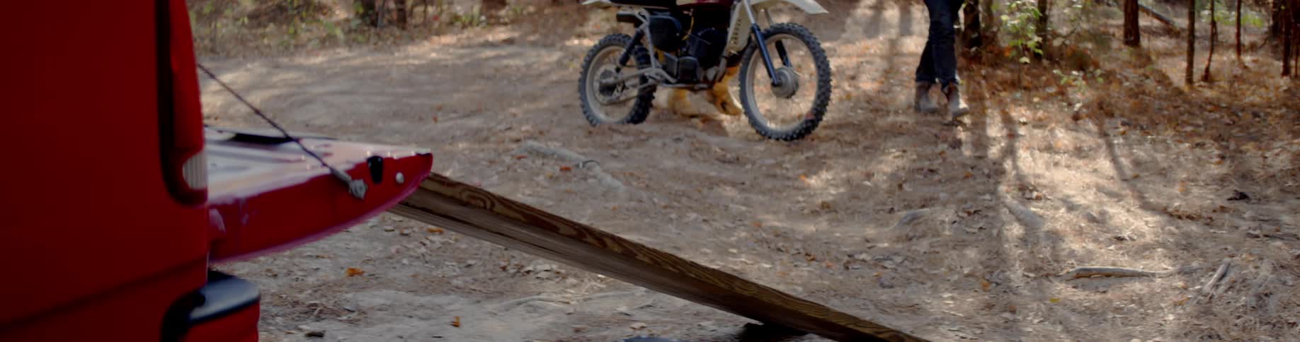 Someone is pushing their dirt bike on the rocks