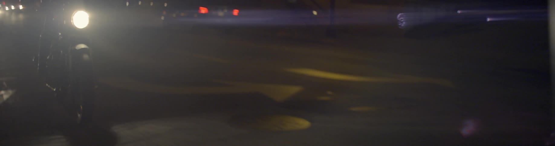 Car headlights on a dim road