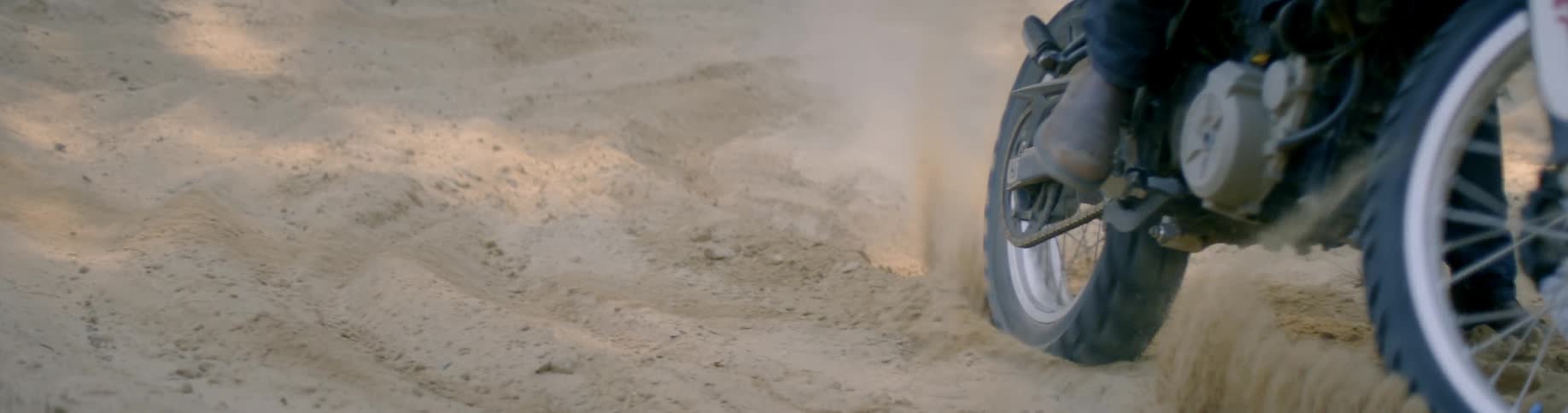 A tire cuts through a sandy area