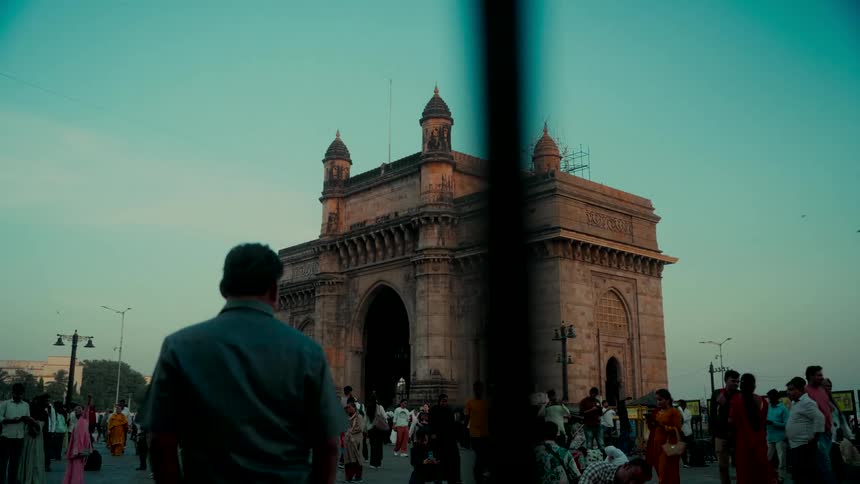 A beautiful shot of the historic Gateway of India in Mumbai at sunset with bustling crowds of people