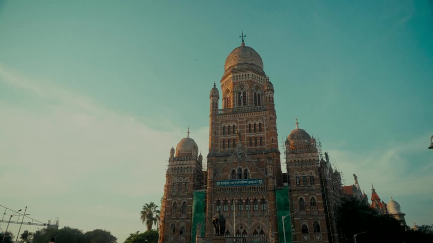 A low-angle shot of the majestic Municipal Corporation Building in Mumbai, India, basking in the warm glow of the setting sun