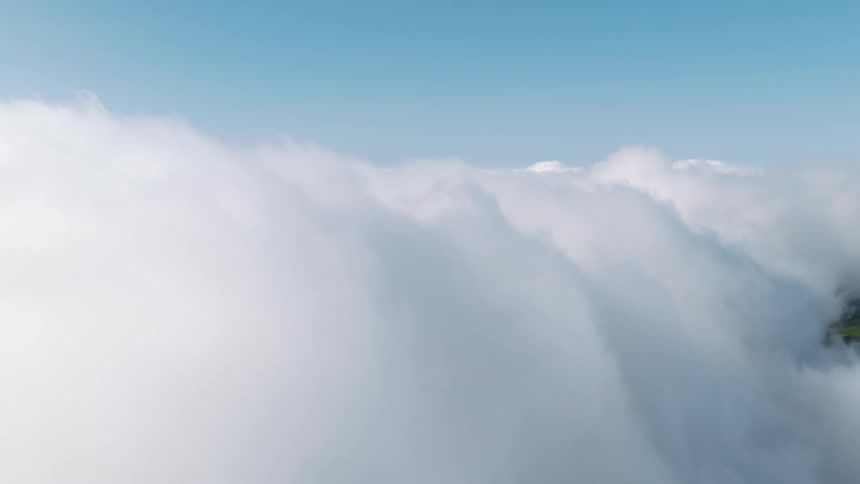 Serene aerial flight over a vast sea of fluffy white clouds under a clear blue sky