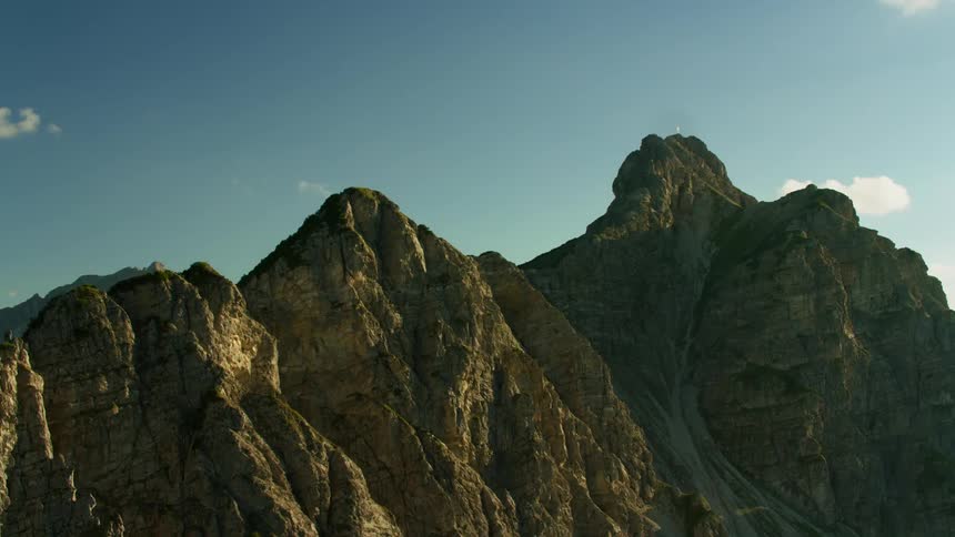 A jagged mountain on a mostly sunny day