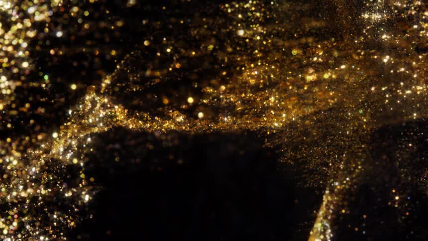 Elegant shimmering gold glitter particles drift and swirl slowly across a dark background