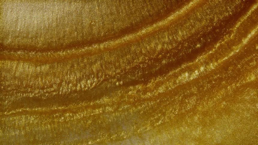 Mesmerizing macro shot of a thick, sparkling golden liquid flowing in slow, shimmering waves, creating a rich abstract background