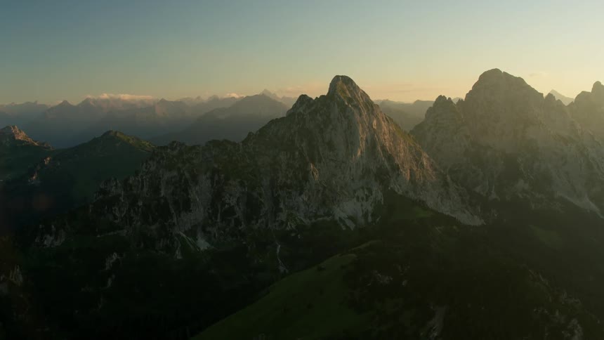 The sun rises beyond a mountain range