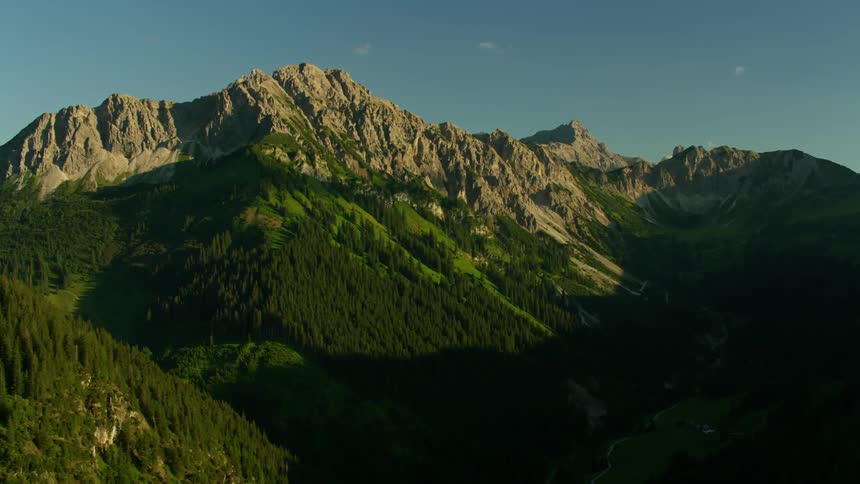 A mountainside is shown on a sunny day