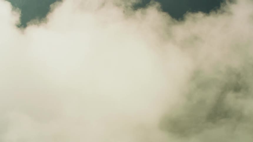Fog rolls over the grass covered mountain