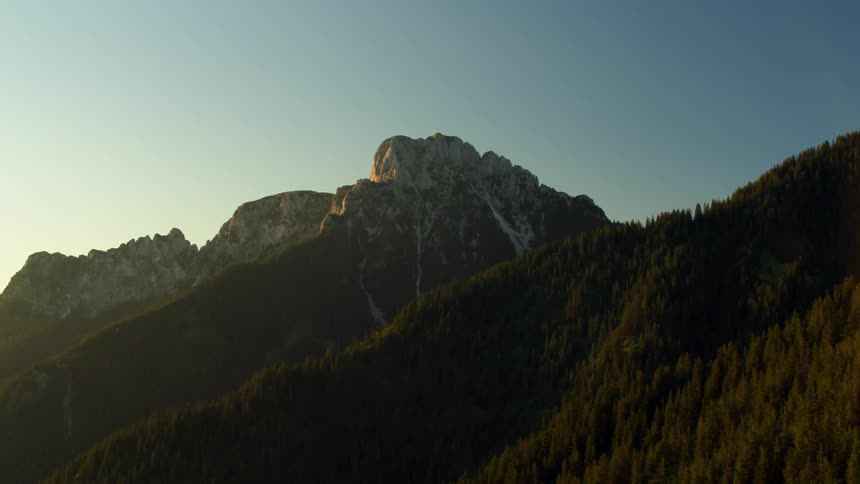A tree covered mountain on a clear day
