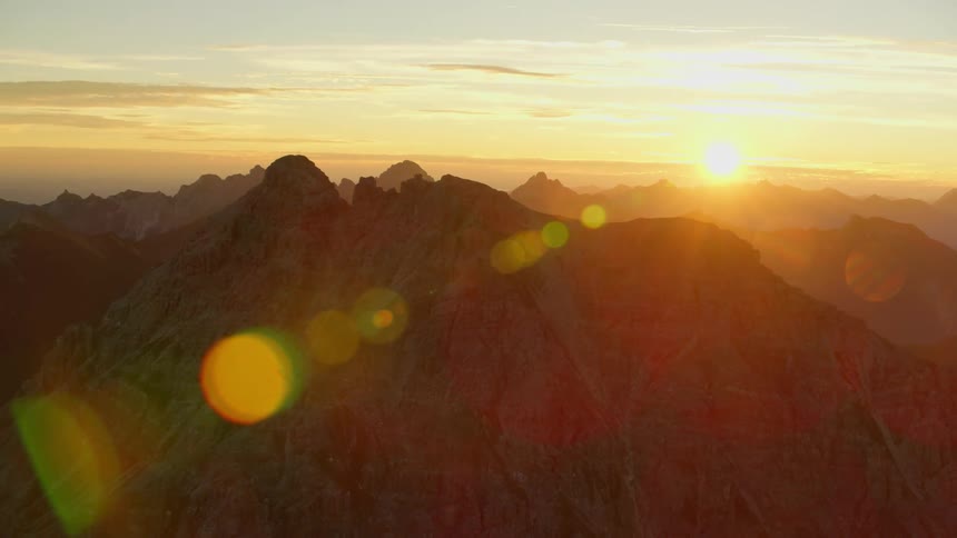 The sun is setting behind these mountains