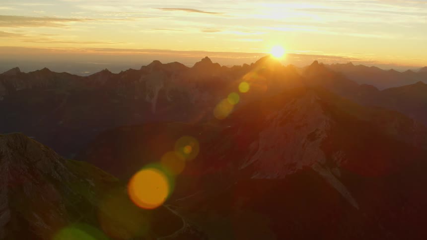 The sun is just setting behind the mountains ahead