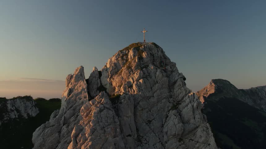 Cross on top of a mountain at sunrise
