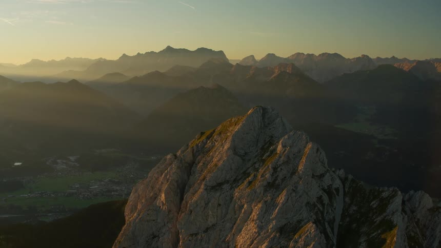 The sun sets over a mountain range