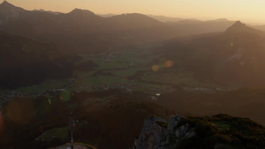 Cross on top of a mountain at sunrise