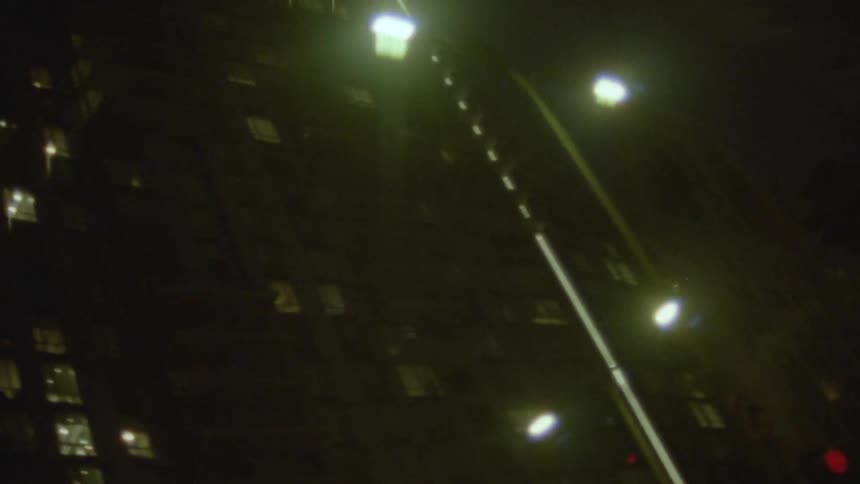 A vintage, out-of-focus POV shot captures a nighttime drive through the freeways and streets of downtown Los Angeles