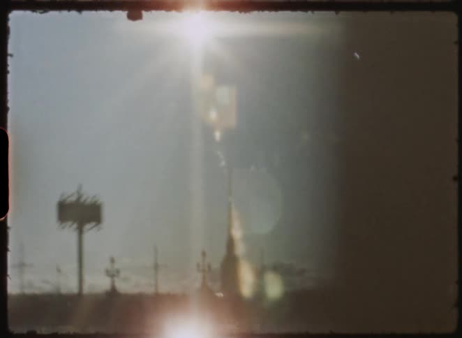 Vintage 8mm film captures a dreamy, sun-drenched view of the Admiralty Building and a bridge over the Neva River in St. Petersburg