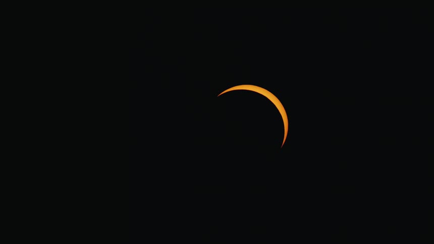 A breathtaking time-lapse captures the crescent sliver of a solar eclipse moving across the dark night sky