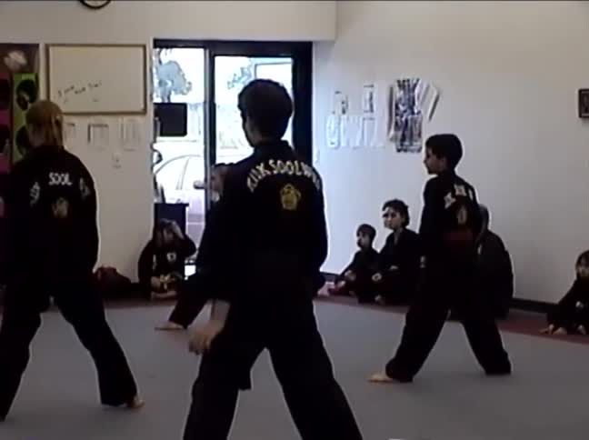 A vintage clip of a children's Kuk Sool Won martial arts class practicing their forms in unison