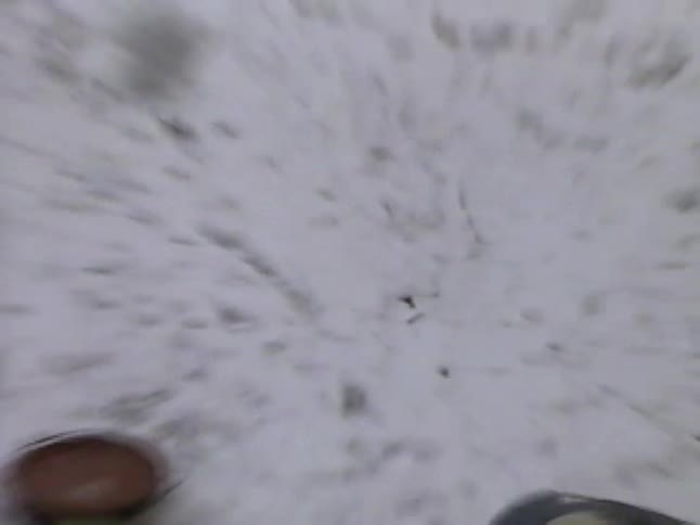 A point-of-view shot captures the moment of getting hit by a snowball and falling to the ground during a playful backyard fight in winter