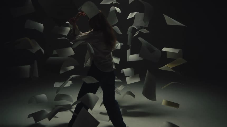Cinematic slow motion shot of a distressed woman frozen in time amidst a chaotic storm of flying documents