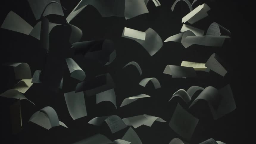 Dramatic slow-motion shot of loose papers and documents floating against a black background