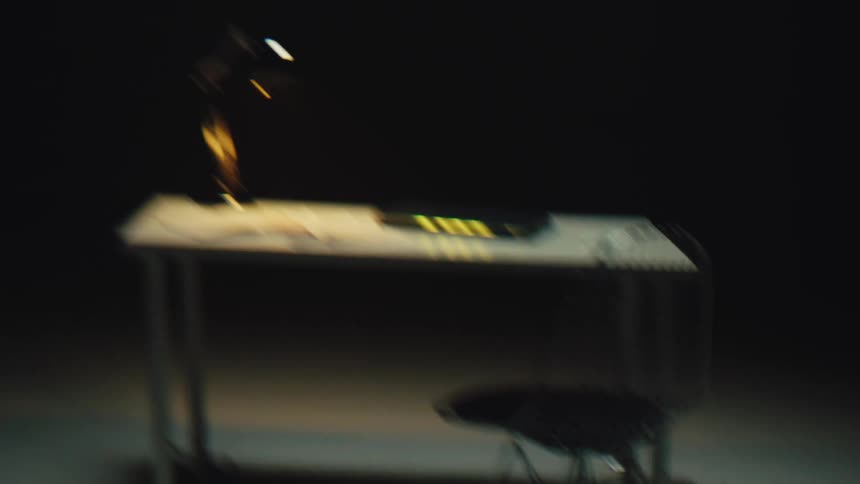 A modern desk in a dark room comes into focus through a digital glitch effect as smoke appears
