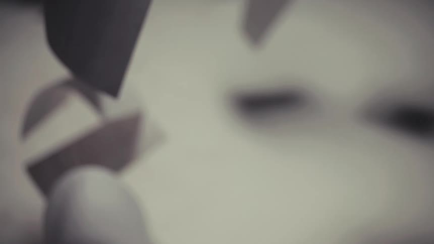 Artistic slow-motion shot of individual sheets of paper floating and falling against a dark background