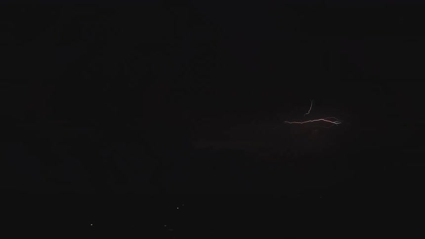 Dramatic lightning flashes and branches across a stormy night sky