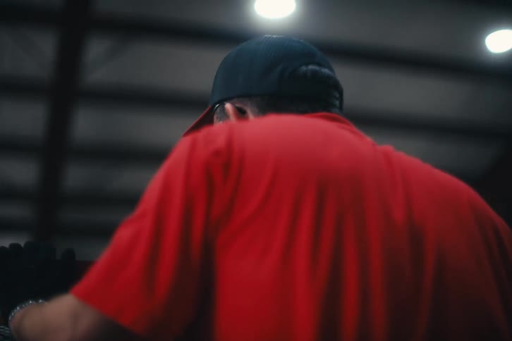 Cinematic slow-motion shot following a male industrial worker as he operates machinery in a factory