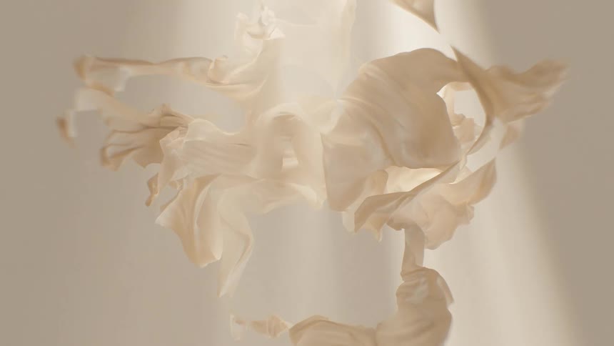 Delicate beige crumpled paper gently moves in the soft light, creating an ethereal abstract background
