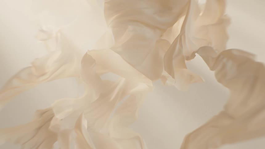 Soft, beige, lightweight fabric flows and undulates gracefully in a slow-motion abstract visual