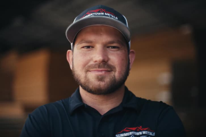 Close-up portrait of a friendly blue-collar worker with a beard smiling warmly at the camera