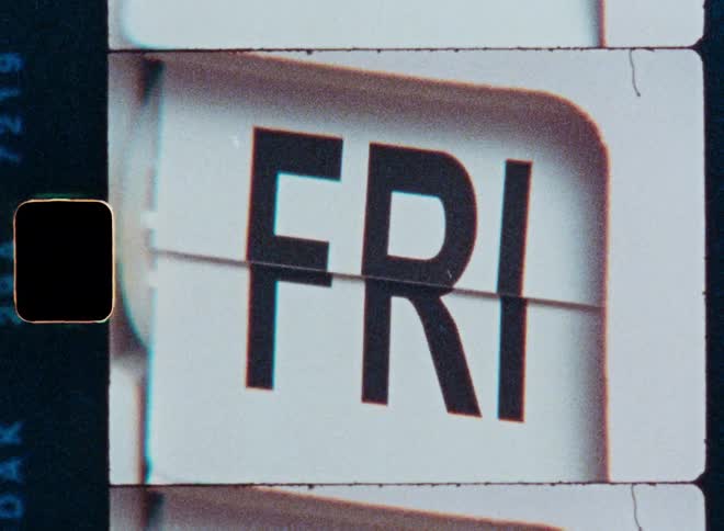 A vintage flip calendar with a retro film aesthetic cycles through the days of the week