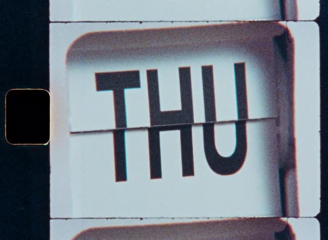 A macro shot with a vintage film aesthetic shows a retro flip calendar cycling through the days of the week