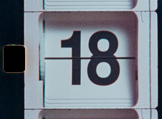 A close-up shot of a retro mechanical flip calendar counting through the days of the month from 1 to 31