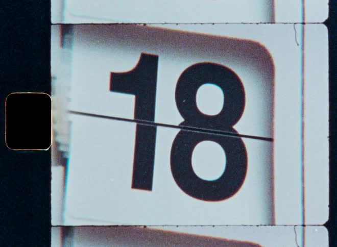 Authentic 8mm film scan of a retro flip calendar counting through the days of a month from 1 to 31