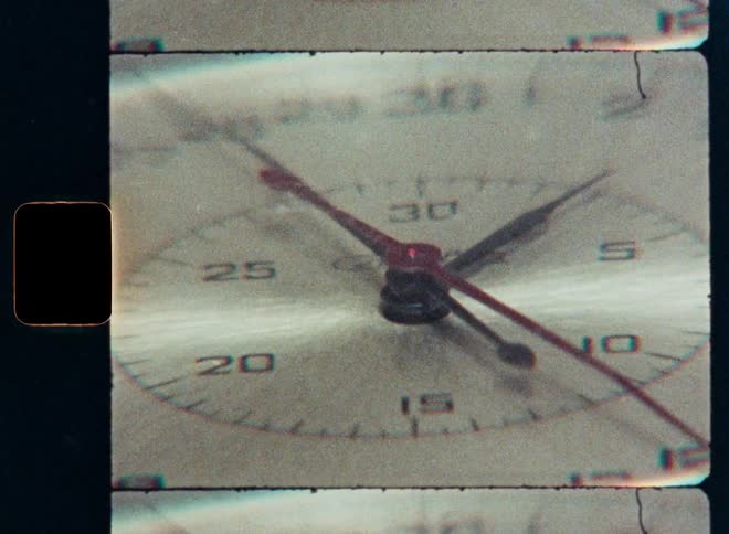 An extreme close-up time-lapse of a vintage clock with fast-moving hands, captured on grainy 8mm film