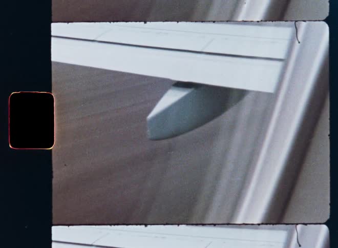 Close-up of an airplane wing speeding down the runway captured on vintage film