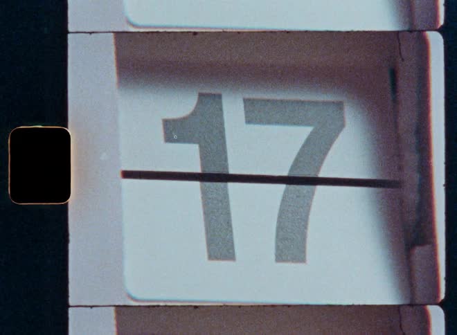 A macro shot of a vintage flip clock counting through the days of the month from one to thirty-one with an old film aesthetic