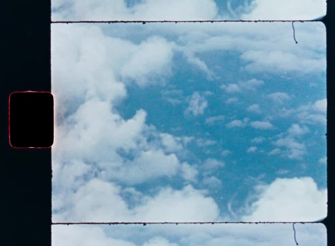 A vintage film strip shows a static shot of a beautiful blue sky filled with fluffy white clouds