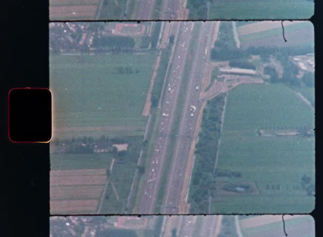 Vintage aerial footage shows a busy highway cutting through a green, rural landscape