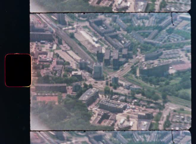 Vintage film captures a sweeping aerial view of a European city from an airplane window