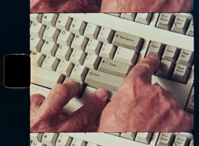 A retro-style close-up of a person's hands pressing Control-Alt-Delete on an old computer keyboard