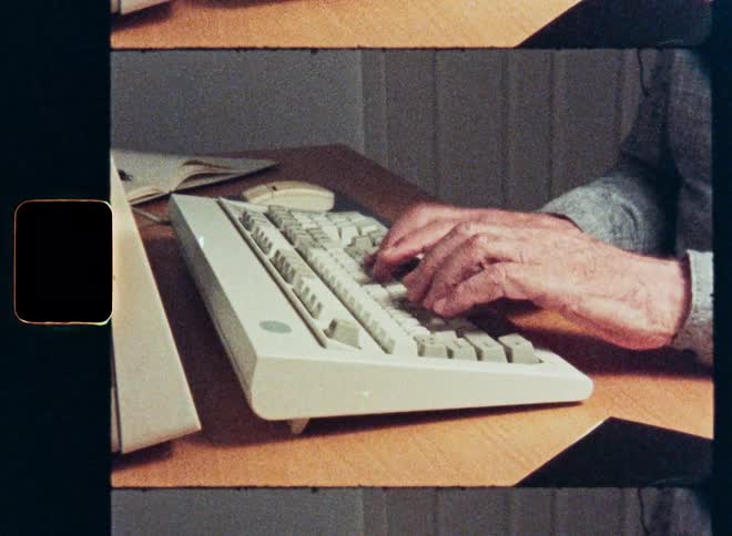 A close-up shot of hands typing on a vintage computer keyboard, captured on grainy film with a split-screen effect