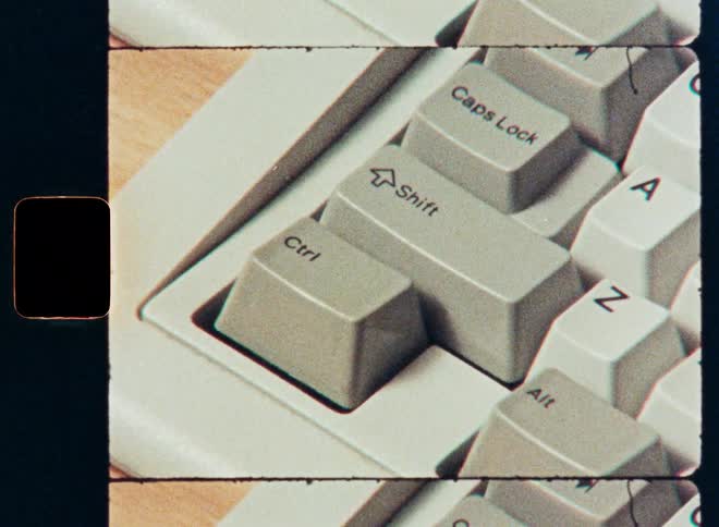 A close-up shot of a finger pressing the shift key on a vintage computer keyboard, captured on retro film
