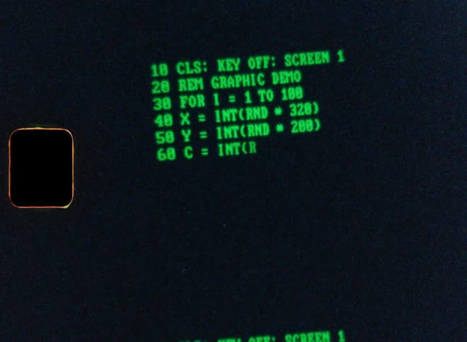 A close-up shot of a BASIC computer program being typed onto a vintage green monochrome screen